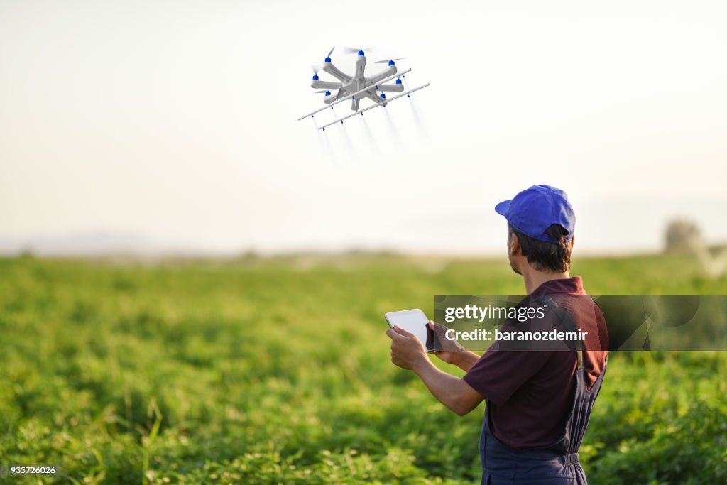 Farmer spraying his crops using a drone