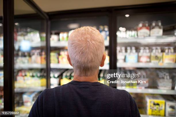 senior man goes grocery shopping. - white hair stock-fotos und bilder