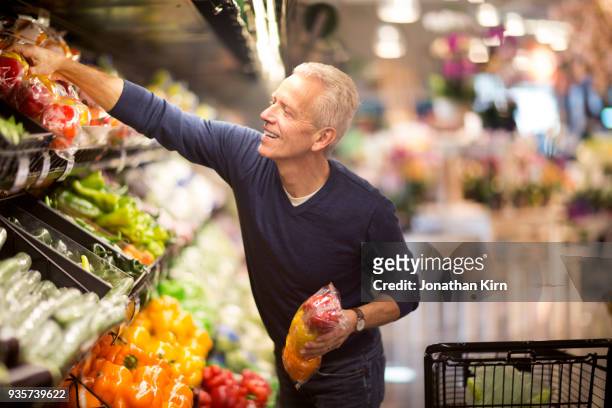 senior man goes grocery shopping. - senior essen stock-fotos und bilder