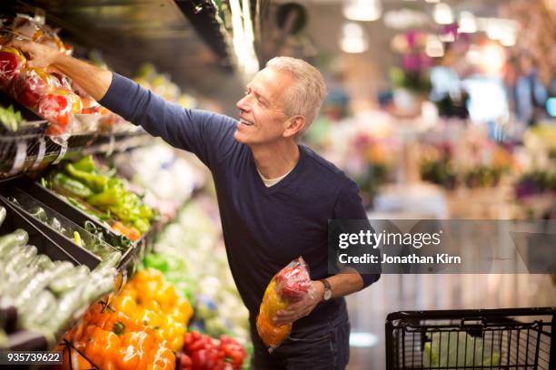 senior man goes grocery shopping. - supermarket shopping stock pictures, royalty-free photos & images