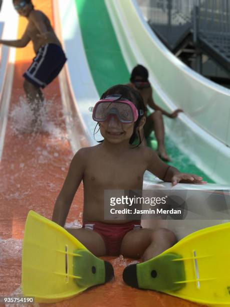 kids sliding into pool - family sports centre laughing stock-fotos und bilder