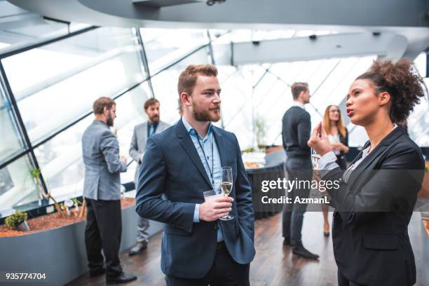 unternehmer und unternehmerin champagner trinken, während einer pause - sektempfang stock-fotos und bilder
