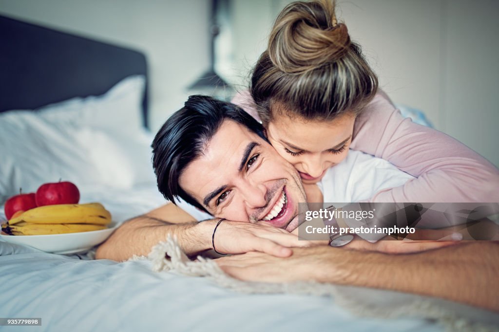 Couple is hugging on the bed in the morning