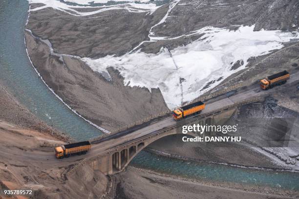 miner's trucks go through the bridge in xinjiang anjihai valley - china environment mine stock-fotos und bilder