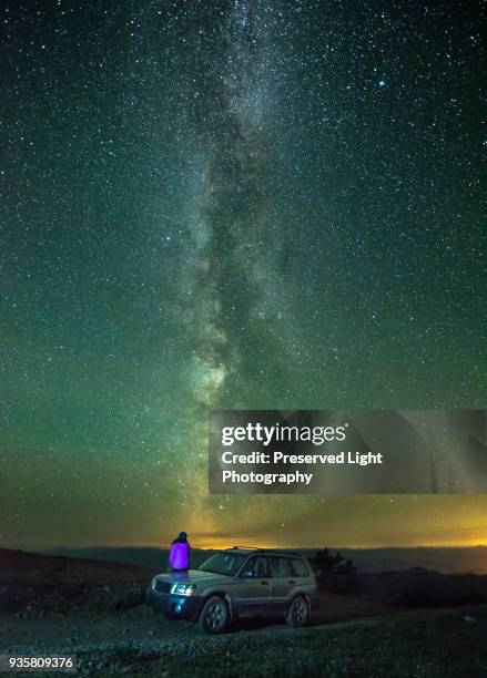 person sitting on car, looking at view of milky way, rear view, nickel plate provincial park, penticton, british columbia, canada - penticton stockfoto's en -beelden