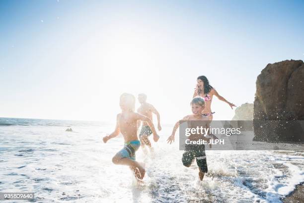 family playing on el matador beach, malibu, usa - malibu beach california stock pictures, royalty-free photos & images