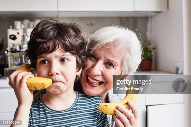 grandmother and grandson fooling around, using bananas as telephones, laughing - family portrait humor fotografías e imágenes de stock