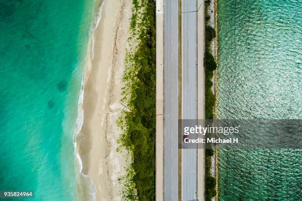 aerial view of linear road and blue sea. - beach car stock pictures, royalty-free photos & images