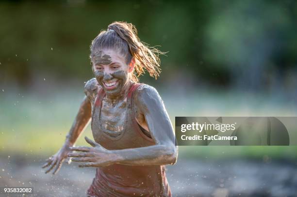 woman doing a mud run - mud runner stock pictures, royalty-free photos & images