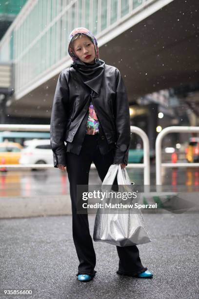 Guest is seen wearing a black leather jacket with silver bag and ornate head scarf during the Amazon Fashion Week TOKYO 2018 A/W on March 21, 2018 in...