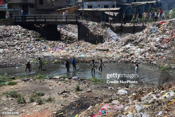 Bangladeshi workers making a small channel in the dry branch river of Buriganga river in Dhaka, Bangladesh, on March 21, 2018. World Water Day is...