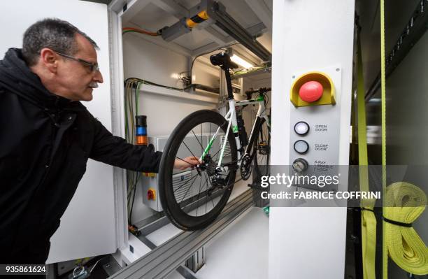 Technician places a bicycle inside an new International Cycling Union mobile X-ray machine box during a press conference unveiling a beefed-up set of...