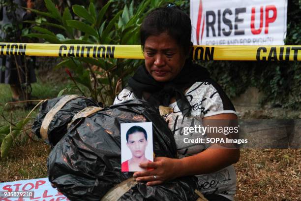 Mother of an extra-judicial killing holds a mock victim of the drug war. Members of the clergy, and the Sto. Domingo community held a Penitential...