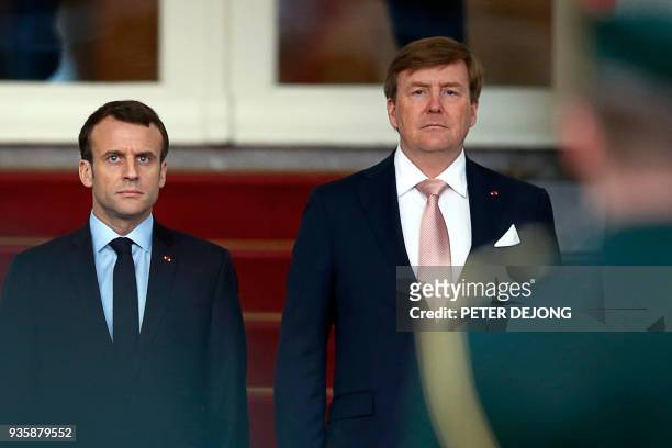 French President Emmanuel Macron , and Dutch King Willem-Alexander listen to the national anthem prior to inspecting the honor guard at royal palace...