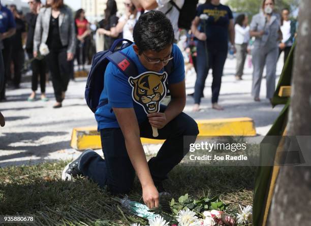 Friends, family, Florida International faculty and students lay flowers at a makeshift memorial as they mourn together during a vigil for victims of...