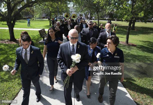 President Mark B. Rosenberg leads a procession of friends, family, Florida International faculty and students as they mourn together during a vigil...