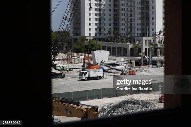 The site of last weeks pedestrian bridge collapse is seen as people attend a vigil for victims of the collapse on the Florida International...