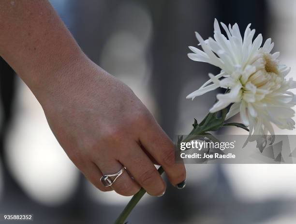 Friends, family, Florida International faculty and students lay flowers at a makeshift memorial as they mourn together during a vigil for victims of...