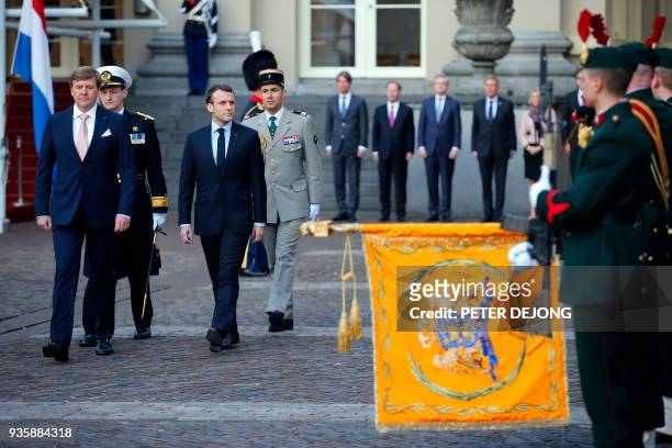 French President Emmanuel Macron , and Dutch King Willem-Alexander inspect the honor guard at royal palace Noordeinde in The Hague on March 21, 2018....