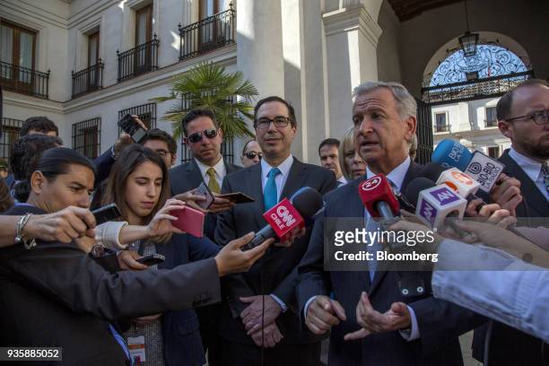 Felipe Larrain, Chile's finance minister, right, speaks with members of the media while Steven Mnuchin, U.S. Treasury secretary, center, listens...