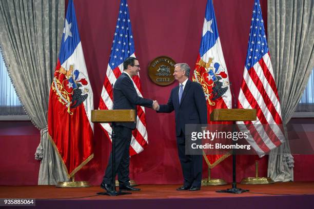 Felipe Larrain, Chile's finance minister, right, shakes hands with Steven Mnuchin, U.S. Treasury secretary, during a press conference at La Moneda...