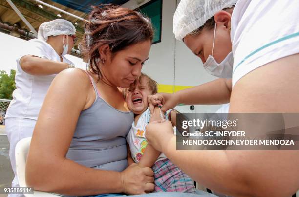 Venezuelan woman and her baby are vaccinated against measles in Cucuta, Colombia, at the international brigde Simon Bolivar on the border with...