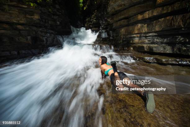 a young japanese girl laying in fast flowing river falls - yaeyama islands stock pictures, royalty-free photos & images
