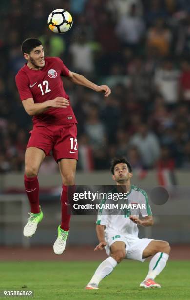Iraq's Hussain Ali Jasim vies for the ball against Qatar's Karim Boudiaf during the international friendly football match between Iraq and Qatar at...