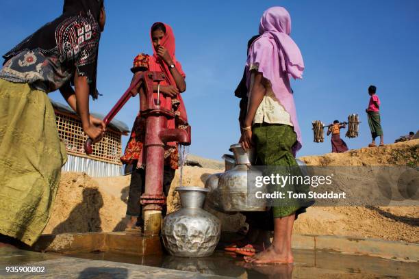 Rohingya girls collect water from a pump in Kutupalong refugee camp on February 27, 2018 at Cox's Bazar, Bangladesh. Over 655,000 Rohingya have...