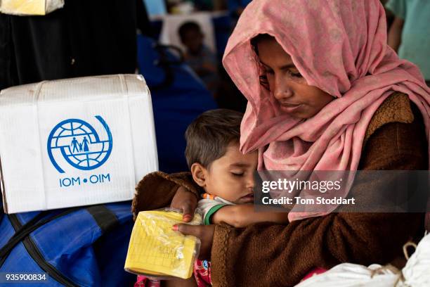 Rohingya woman and her baby boy wait for aid to be distributed by the International Organisation for Migration and Shelterbox UK after arriving at...