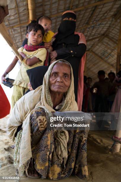 An elderly Rohingya woman waits in line at a distribution of food and blankets by the Bangladesh army at Noya Para on February 25, 2018 near Cox's...
