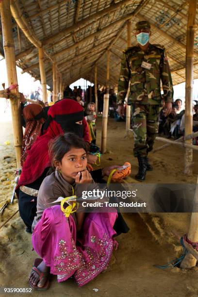 Rohingya girl waits in line at a distribution of food and blankets by the Bangladesh army at Noya Para on February 25, 2018 near Cox's Bazar,...