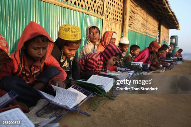 Rohingya boys study the Koran at dawn outside a mosque in Kutupalong refugee camp on February 29, 2018 at Cox's Bazar, Bangladesh. Over 655,000...
