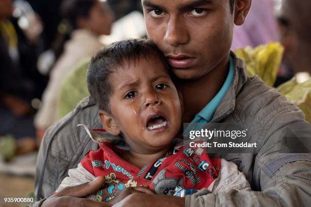 Rohingya man and his distraught son wait for aid provided by the International Organisation for Migration and Shelterbox UK after arriving at...