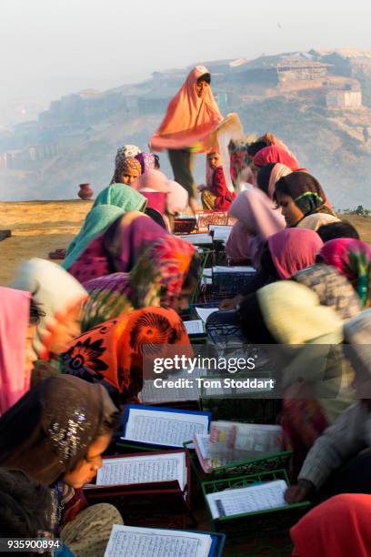 Rohingya girls study the Koran at dawn outside a mosque in Kutupalong refugee camp on February 29, 2018 at Cox's Bazar, Bangladesh. Over 655,000...