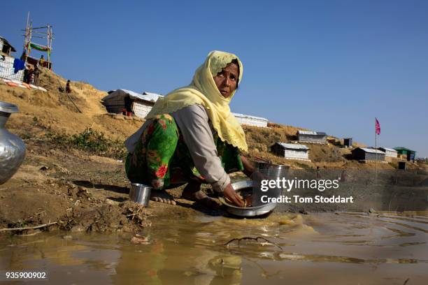 Rohingya woman washes cooking utensils at a pool of water in Kutupalong refugee camp on February 28, 2018 at Cox's Bazar, Bangladesh. Over 655,000...