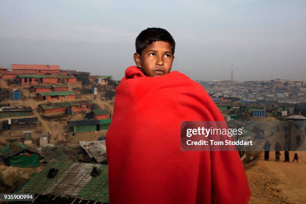 Year old Hossion Juhar wrapped up in a blanket to keep warm on a cold morning at Kutupalong refugee camp on February 27, 2018 at Cox's Bazar,...