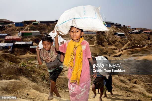 Rohingya children carry firewood in sacks to their homes at Kutupalong refugee camp on February 26, 2018 at Cox's Bazar, Bangladesh. Hundreds of...