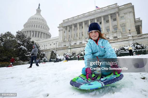 People snow sled on the grounds of the U.S. Capitol March 21, 2018 in Washington, DC. An early spring storm brought several inches of snow to the...