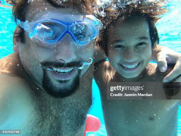 father diving under water with sons - turkish boy stock pictures, royalty-free photos & images
