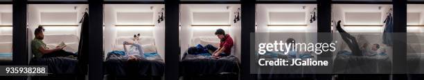 group of young adults relaxing in a capsule hotel - pousada de juventude imagens e fotografias de stock