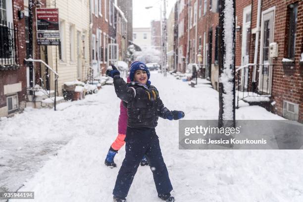 Kenny Racowski launches a snowball at his parents on March 21, 2018 in Philadelphia, Pennsylvania. The fourth nor'easter in three weeks has forced...