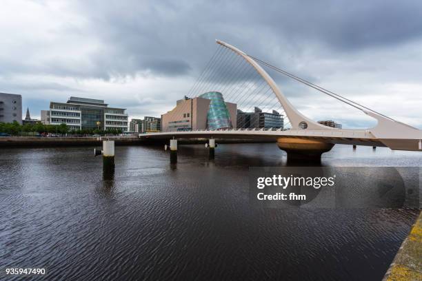 samuel beckett bridge in dublin with liffey river and city skyline (dublin/ ireland) - convention centre dublin stock pictures, royalty-free photos & images