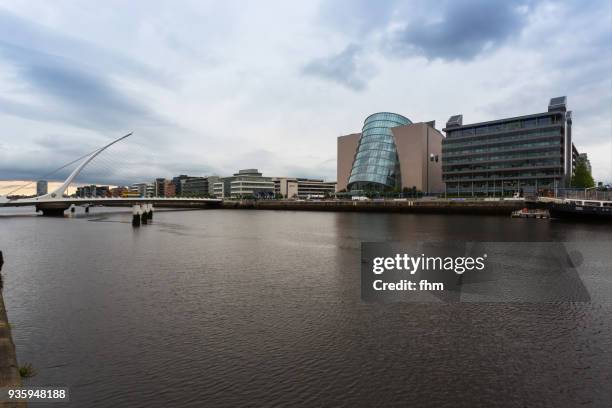 samuel beckett bridge in dublin with liffey river and city skyline (dublin/ ireland) - convention centre dublin stock pictures, royalty-free photos & images