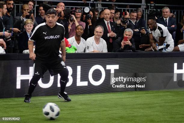 Manchester United manager Jose Mourinho takes a photo next to Jamaican sprinter Usain Bolt as they watch veteran Argentinian footballer Diego...