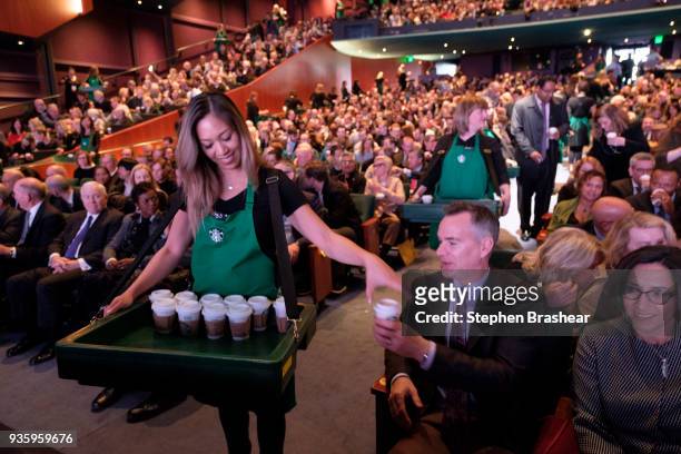 Starbucks partners pass out coffee to shareholders for a tasting during Starbucks' annual shareholders meeting at McCaw Hall on March 21, 2018 in...
