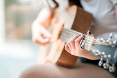 woman hands playing acoustic guitar