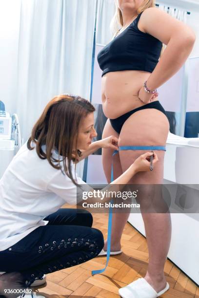 woman using measuring tape to assess leg volume - woman with thick legs imagens e fotografias de stock