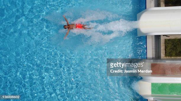excited children in water park riding on slide - aerial view - water slide stock pictures, royalty-free photos & images