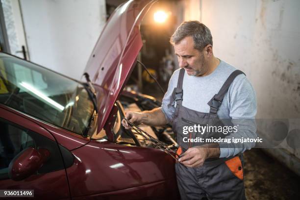 männliche mechaniker reparieren kaputtes auto - autowerkstatt gegenlicht stock-fotos und bilder